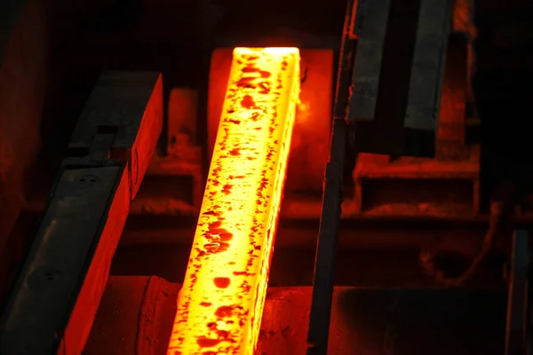 Erimiş çeliğin dökülmesinden sonra, kırmızı çelik çubuklar. Devamlı döküm makinesi. Demirci ve metalurji endüstrisinin arka planı.
