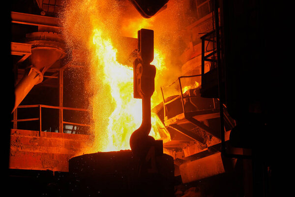 Steel production in electric furnaces. Sparks of molten steel. Electric arc furnace shop EAF. Metallurgical production, heavy industry, engineering, steelmaking.