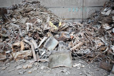 Hurdalıkta paslı demir atığının üzerine metal döküntüsü. Demir hammaddeler geri dönüşüme hazır..