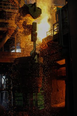 Elektrikli fırınlarda çelik üretimi. Erimiş çelikten kıvılcımlar. Elektrikli ark fırını EAF. Metalurjik üretim, ağır sanayi, mühendislik, çelik yapımı