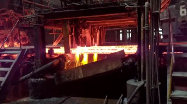 Meşalenin yanındaki çelik bölmeler metalürjik bitkileri kesiyor. Metalurjik üretim, ağır sanayi, mühendislik, çelik yapımı