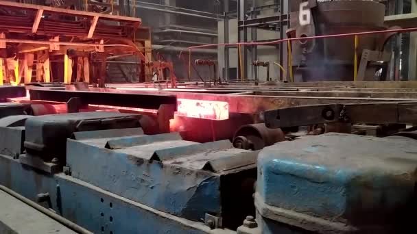 Erimiş çeliğin dökülmesinden sonra, kırmızı çelik çubuklar. Devamlı döküm makinesi. Demirci ve metalurji endüstrisinin arka planı. — Stok video