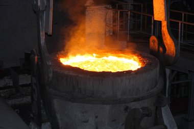Elektrikli fırınlarda çelik üretimi. Erimiş çelikten kıvılcımlar. Elektrikli ark fırını EAF. Metalurjik üretim, ağır sanayi, mühendislik, çelik yapımı