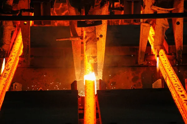 Meşalenin yanındaki çelik bölmeler metalürjik bitkileri kesiyor. Metalurjik üretim, ağır sanayi, mühendislik, çelik yapımı