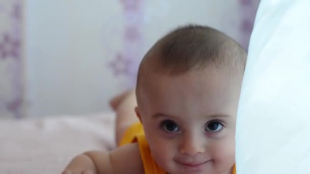 美しい笑顔の赤ちゃん。素敵な小さな赤ちゃんがベッドの上に横たわって笑顔. — ストック動画
