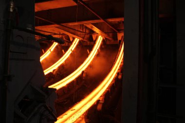 Erimiş çeliğin dökülmesinden sonra, kırmızı çelik çubuklar. Devamlı döküm makinesi. Demirci ve metalurji endüstrisinin arka planı.
