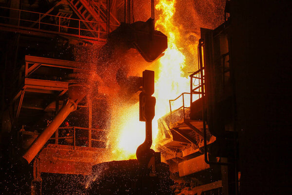 Steel production in electric furnaces. Sparks of molten steel. Electric arc furnace shop EAF. Metallurgical production, heavy industry, engineering, steelmaking.