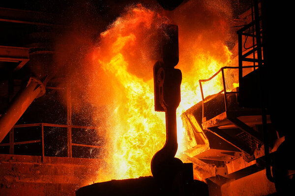 Steel production in electric furnaces. Sparks of molten steel. Electric arc furnace shop EAF. Metallurgical production, heavy industry, engineering, steelmaking.