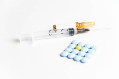 Coronavirus 2019-nCoV salgını. Beyaz bir arka planda haplar ve şırıngalar