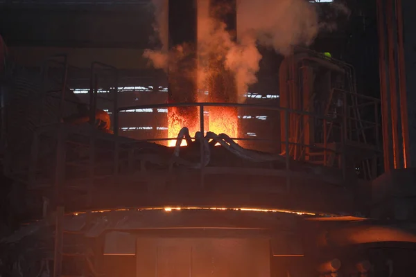 Elektrikli fırınlarda çelik üretimi. Erimiş çelikten kıvılcımlar. Elektrikli ark fırını EAF. Metalurjik üretim, ağır sanayi, mühendislik, çelik yapımı.