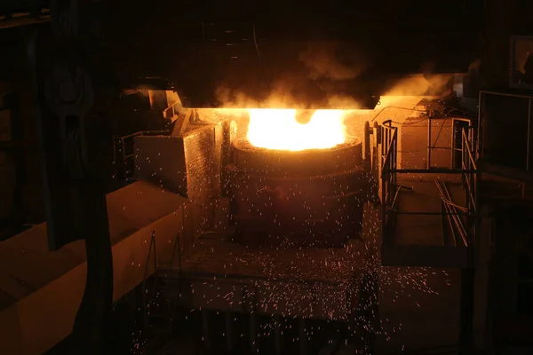 Steel production in electric furnaces. Sparks of molten steel. Electric arc furnace shop EAF. Metallurgical production, heavy industry, engineering, steelmaking.