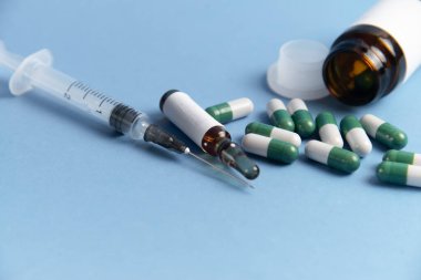 Coronavirus 2019-nCoV salgını. Mavi arka planda haplar ve şırıngalar. Hap ve ilaç, hastalık sırasında bakım..