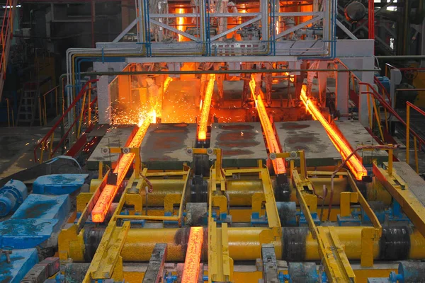 Erimiş çeliğin dökülmesinden sonra, kırmızı çelik çubuklar. Devamlı döküm makinesi. Demirci ve metalurji endüstrisinin arka planı.