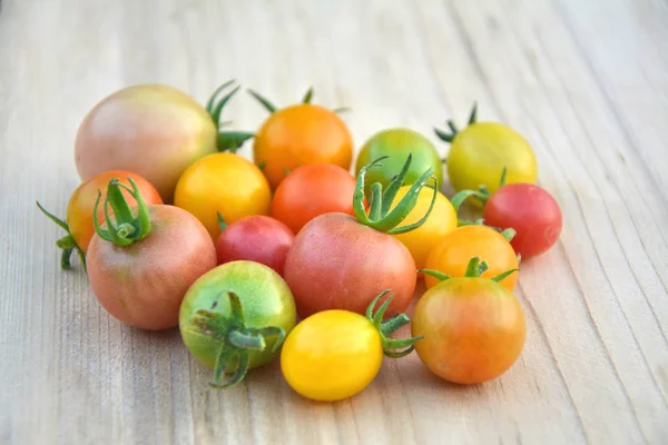 Colorful various cherry tomatoes on wooden background