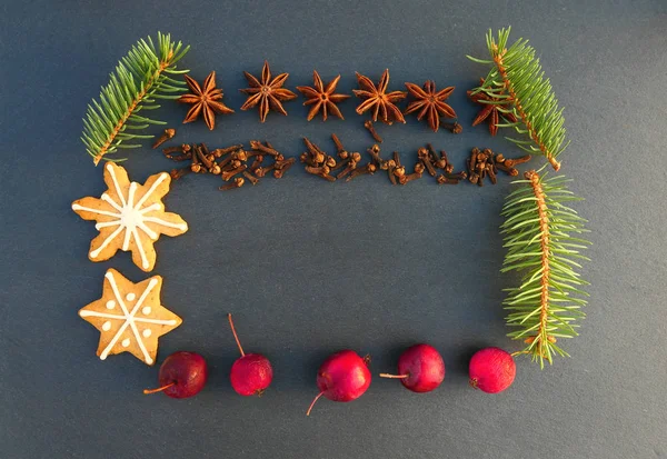クリスマス ナチュラル フレーム装飾 木の枝 クッキー スパイス 黒い石の背景にリンゴを小ぎれいにしなさい — ストック写真