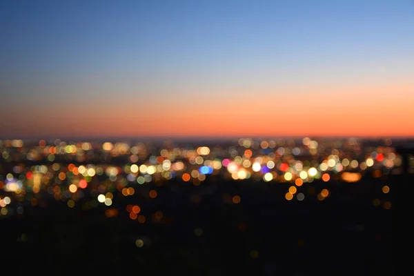 Luzes Bokeh de uma cidade ao pôr-do-sol . — Fotografia de Stock