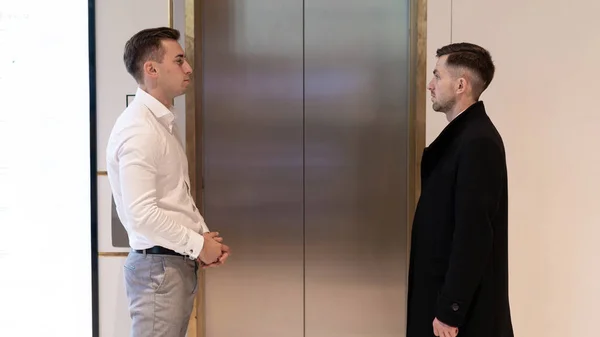 Business team group going on elevator. Business people in a large glass elevator in a modern office