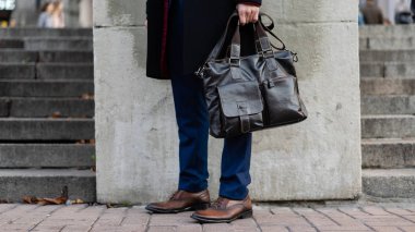 Bir işadamı bir evrak çantası sokakta tutar.