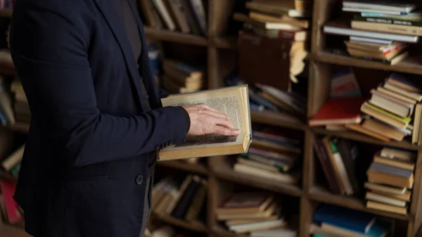Person i svart marinblå kostym innehav bok i händerna — Stockfoto