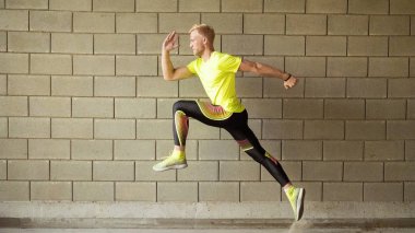 Genç adam, gri duvar arka plan üzerinde çalışan