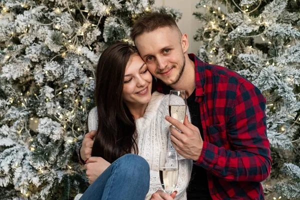 Young romantic couple celebrating New Year near Christmas tree — Stock Photo, Image