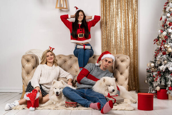 Happy christmas celebrating of young people with dogs and gifts