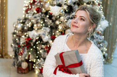 Beyaz kazaklı Hediyelik Noel ağacı yakınındaki ile poz güzel genç sarışın kız portresi yarım uzunluk