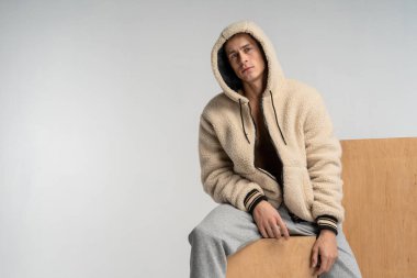 Bir adam gri pantolon ahşap bir küp üzerinde oturan çıplak bir gövde ile