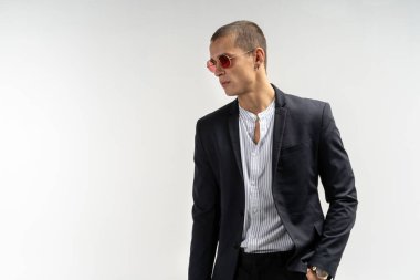 Takım elbiseli şık genç adam. İş tarzı. Fashinable görüntü. Ofis çalışanı. Ayakta ve kameraya bakarak seksi adam