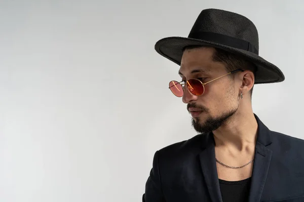 Retrato de primer plano de hombre guapo en gafas de sol redondas, traje negro y sombrero — Foto de Stock