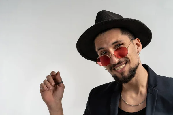 Retrato de primer plano de hombre guapo en gafas de sol redondas, traje negro y sombrero — Foto de Stock