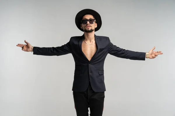 Moteportrett av kjekk elegant mann i svart dress og hatt posende i studio – stockfoto