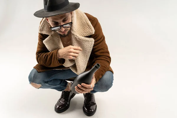 Модный снимок нарядного молодого человека в шляпе и пальто — стоковое фото