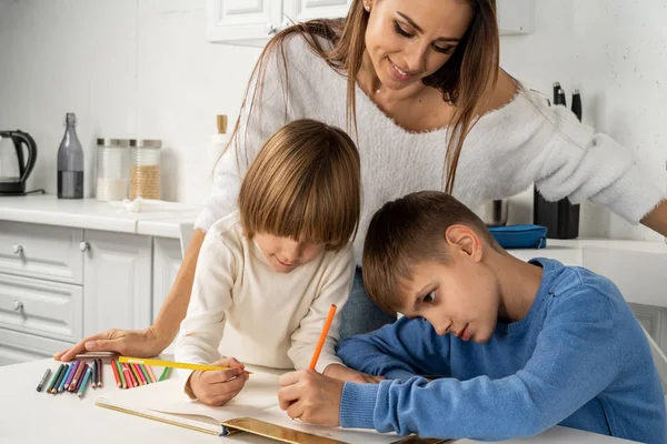 Vacker mor med sina söner att ha kreativa och roliga tid ritning — Stockfoto