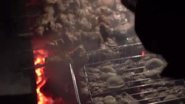 Izgara, kızarmış et, tavuk ızgara, sosis, kebap, hamburger, sebze, barbekü, deniz ürünleri. Izgara biber ve soğan. Yakın çekim güneşli açık hava Şef ızgaradaki eti çeviriyor