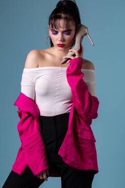 Yüksek topuk ayakkabı gibi bir telefon kullanarak renkli makyaj ile genç kadın moda