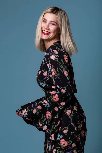 Retrato de perfil de una hermosa joven hembra con pelo rubio y pelo rubio con vestido oscuro con flores —  Fotos de Stock