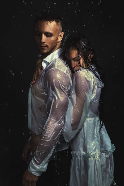 Retrato de pareja sexy en camisa blanca y vestido de pie bajo la lluvia — Foto de Stock