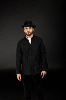 Siyah gömlek ve şapka giymiş yakışıklı genç modeli