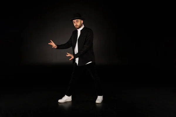 Joven bailarina moderna masculina en ropa negra y sombrero — Foto de Stock
