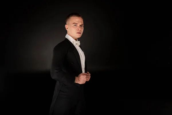 La gente bailando concepto - hombre guapo en traje negro bailando sobre el fondo gris — Foto de Stock