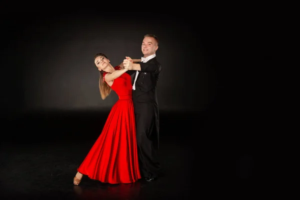 Bailarines latinos en acción. Hermosa pareja sobre fondo gris — Foto de Stock