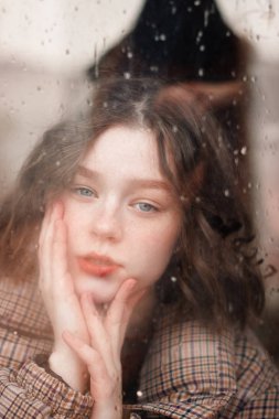 Yağmur damlaları ile pencereden ateş etti. Güzel kıvırcık kız