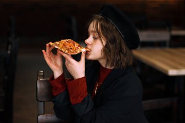 Yan görünümü nlack şapkalı genç kıvırcık kız portresi