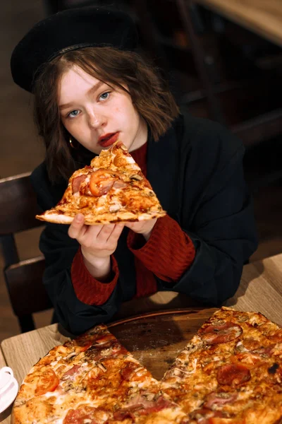Kręcone dziewczyna niebieski oczy jedzenie pizzy w kawiarni — Zdjęcie stockowe
