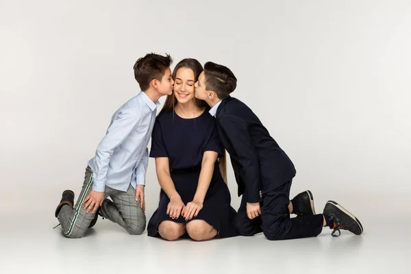 Två unga bror gentelmans kysser sin äldre syster — Stockfoto