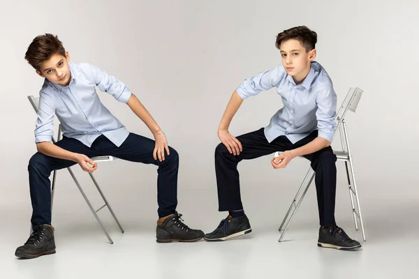 Två pojkar tonåringar i blå tröjor och svarta byxor — Stockfoto