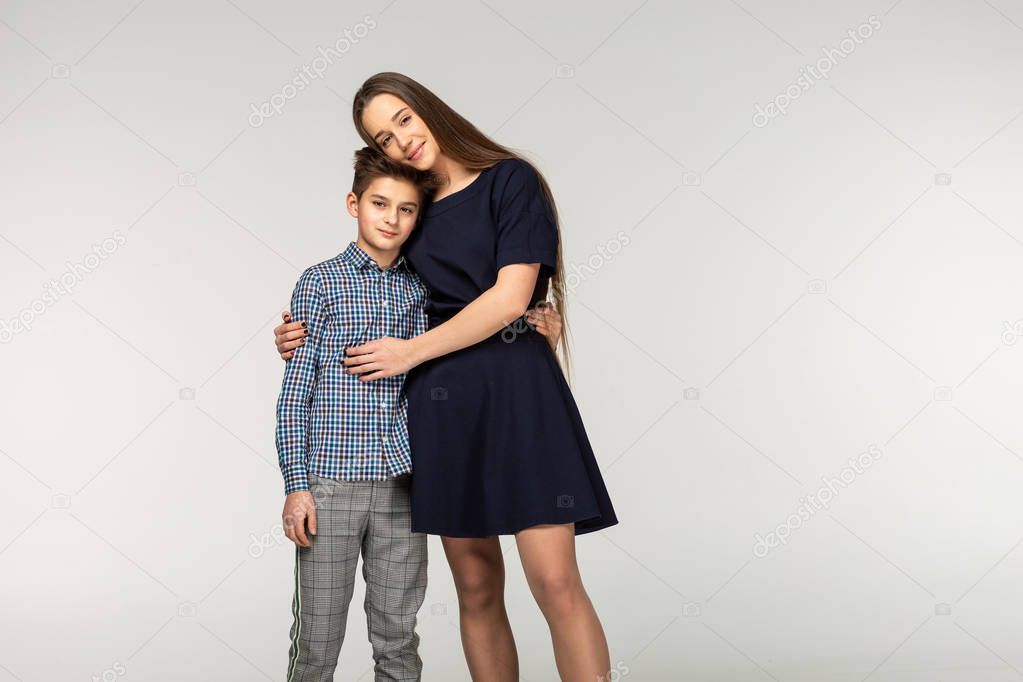 Beautiful sister and brother hugging tenderly indoors