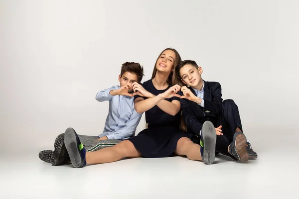 Mooie zuster zittend op de grond met twee jongere broers — Stockfoto