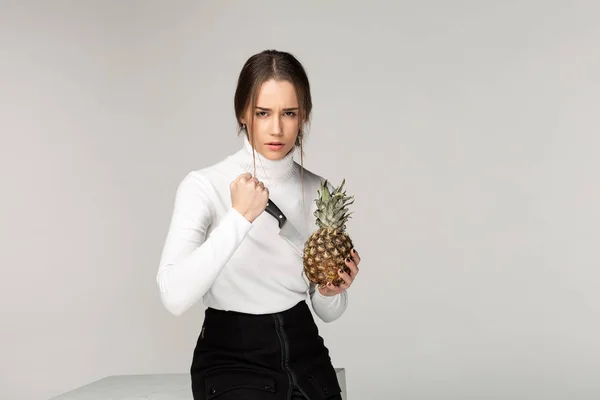 Szép fiatal lány vágás ananász tekintete mániákus — Stock Fotó